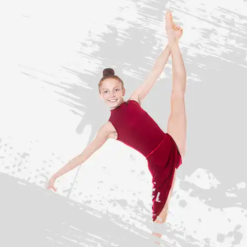 Dziewczynka w gimnastycznej pozycji trzymająca wyprostowaną nogę nad głową